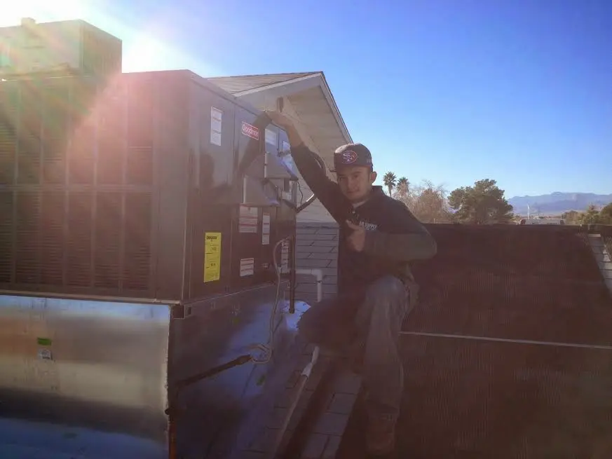 HVAC technician performing Air Duct Cleaning on a rooftop unit in Ann Arbor